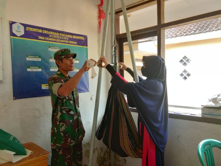 BABINSA KORAMIL 2204/CIKIDANG DAMPINGI KEGIATAN POSYANDU DAHLIA DI DESA CICAREUH