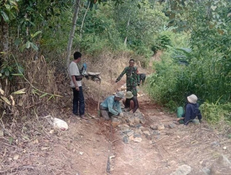 Babinsa Koramil 2207/Jampangtengah Laksanakan Karya Bakti Pengerasan Jalan Menuju Sekolah
