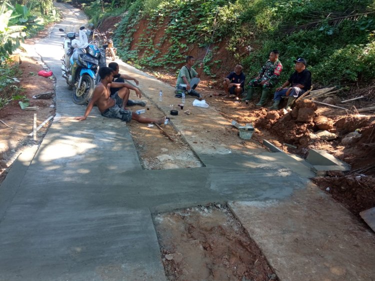 Babinsa Koramil 2204/Cikidang Laksanakan Karya Bakti Rapat Beton Jalan di Desa Tamansari
