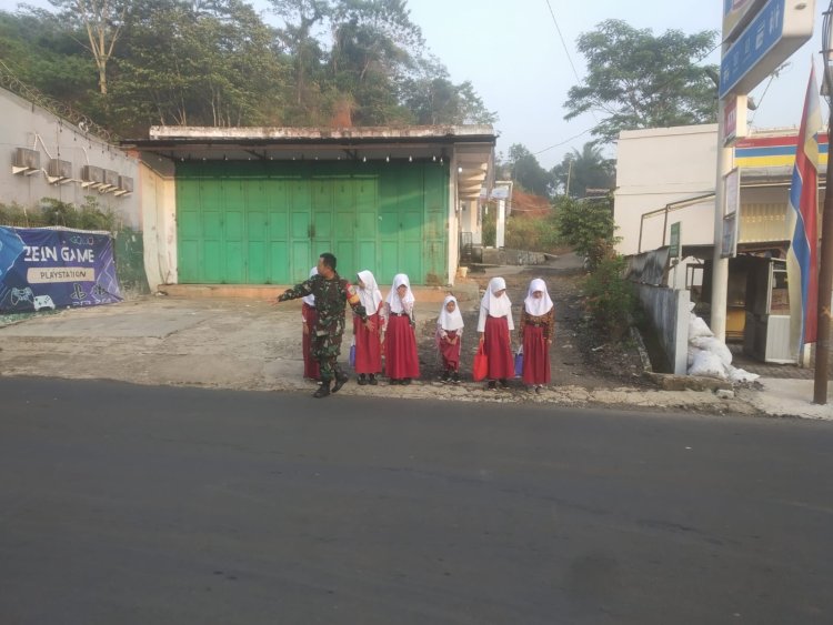 Babinsa Koramil 2204/Cikidang Bantu Penyebrangan Siswa Sekolah Dasar