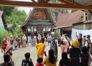 Para pengunjung tampak manortor (menari,red) saat mengunjungi Patung Siga-gale.