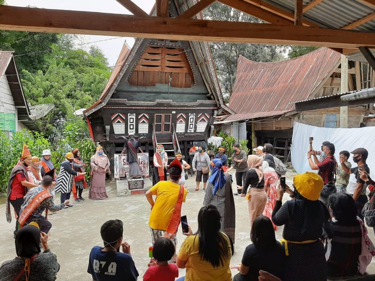 Para pengunjung tampak manortor (menari,red) saat mengunjungi Patung Siga-gale.