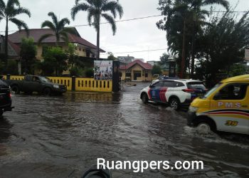 Jalan depan Polsek Siantar Utara kebanjiran pada Rabu sore tadi (10/2/2021).