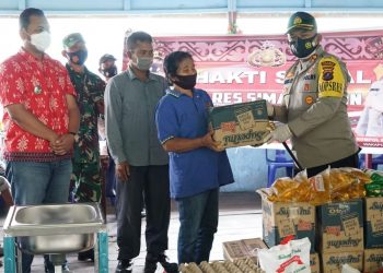 Kapolres Simalungun saat menyerahkan paket sembako kepada masyarakat yang kurang mampu yang ada di Nagori Sibaganding.