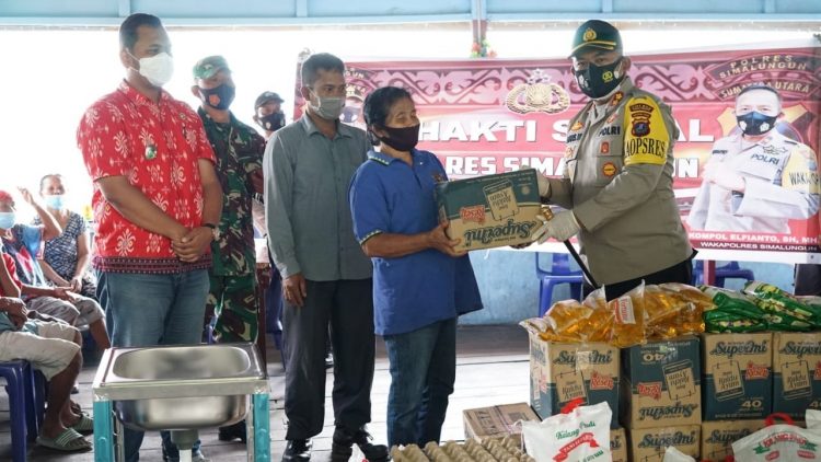 Kapolres Simalungun saat menyerahkan paket sembako kepada masyarakat yang kurang mampu yang ada di Nagori Sibaganding.