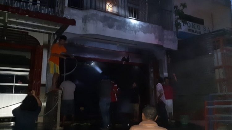 Petugas pemadam kebakaran saat berupaya memadamkan api yang membakar satu unit ruko di Terminal Pangururan, Samosir, Jumat (19/2/2021). (Foto: istimewa)