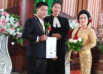 Pasangan pengantin, Gomgom dan Marny, foto bersama Pdt. Sadaria boru Nainggolan usai acara pemberkatan.