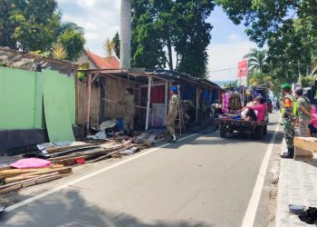 Petugas Satpol PP Simalungun saat membongkar kios souvenir yang terletak di Jalan Pora-Pora, Kelurahan Tigaraja, Kecamatan Girsang Sipangan Bolon (Girsip), Kabupaten Simalungun.