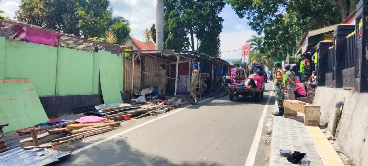 Petugas Satpol PP Simalungun saat membongkar kios souvenir yang terletak di Jalan Pora-Pora, Kelurahan Tigaraja, Kecamatan Girsang Sipangan Bolon (Girsip), Kabupaten Simalungun.