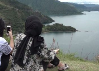 Pengunjung berswafoto di atas Bukit Singgolom, Sumatera Utara. [ANTARA]