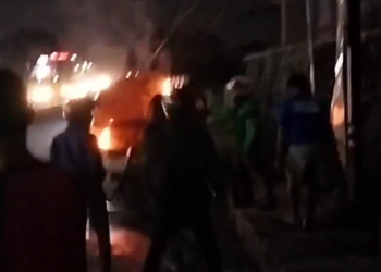Warga bersama petugas Pemadam Kebakaran berusaha memadamkan api yang membakar mobil milik anggota polisi di sekitar persimpangan Underpass Titi Kuning, Kota Medan. Foto: Okezone/Wahyudi Aulia Siregar