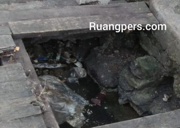 Kondisi drainase di jalan Patuan Nagari, yang dipenuhi sampah, mengakibatkan jalan air tersumbat dan ujung - ujungnya tumpah, menggenangi jalan.