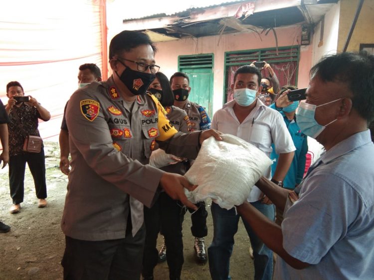 Kapolres Tebing Tinggi, AKBP Agus Sugiyarso SIK saat memberikan sembako kepada masyarakat. (foto/dmk)