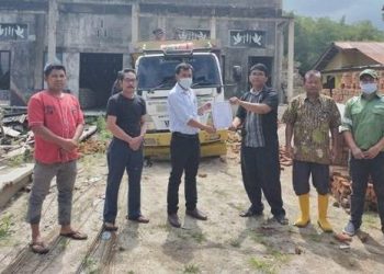 Teks Foto: Humas Sektor Habinsaran PT. Toba Pulp Lestari, Pangeran Marpaung saat serahkan bantuan kepada Pimpinan Gereja HKBP Napitupulu.