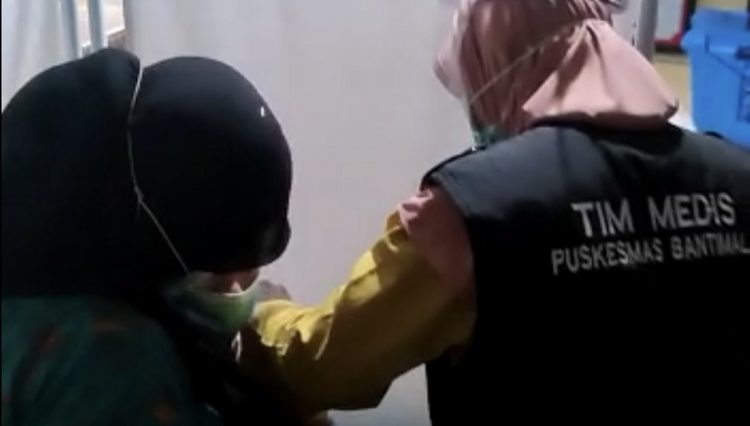Petugas vaksin memegangi tenaga kesehatan yang takut disuntik. (Foto: iNews/Herman Amiruddin).