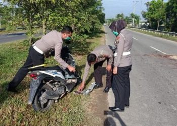 Polisi sedang mengamankan sepeda motor pelajar yang tewas kecelakaan di Jalan Bandara Kualanamu [Foto: Ist]