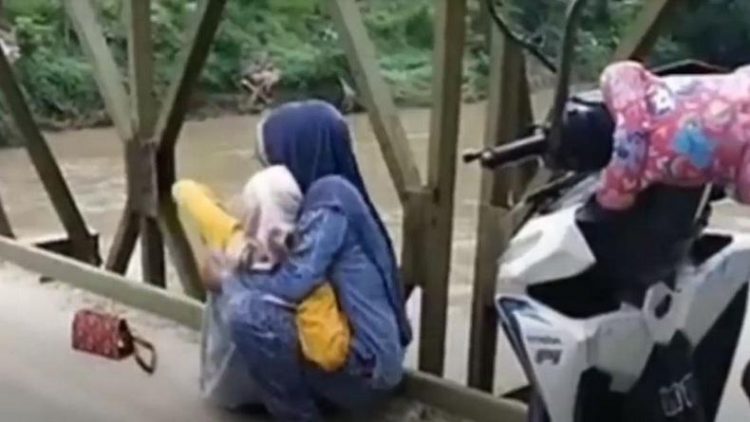 Tangkapan layar saat warga menolong perempuan yang coba bunuh diri meloncat dari atas jembatan di Asahan. (foto: iNews/Ulil Amri)