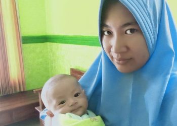 Ririn Linda Tunggal Sari (33) menggendong anaknya yang diberi nama Dinas Komunikasi Informatika Statistik seperti nama tempat kerja suaminya sebagai ASN di Pemkab Brebes, Rabu (7/4/2021) (Dok. Pribadi Ririn Linda Tunggal)(KOMPAS.com/Tresno Setiadi)