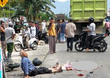 Syahrial (74), terduduk lemas di pinggir jalan, pasrah melihat sang istri yang tewas mengenaskan setelah dilindas truk di kawasan By Pass Ketaping, Kilometer 7, Kecamatan Kuranji, Kota Padang. (Foto: Istimewa)