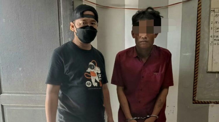 Foto pelaku dengan tangan diborgol.