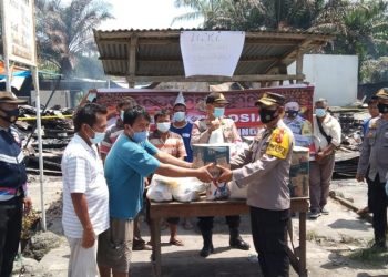 Suasana penyerahan bantuan sembako dari Kapolres Simalungun kepada warga yang rumahnya terbakar.