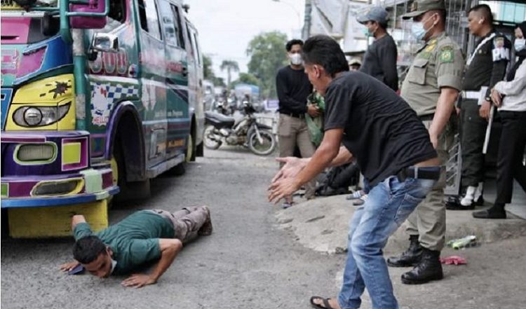 Sopir membawa penumpang di atap angkutan mendapat hukuman push-up di Posko Penyekatan Larangan Mudik di Kota Medan, Senin (17/5/2021). (Foto: ANTARA)