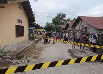 Petugas memasang garis polisi di lokasi kejadian.