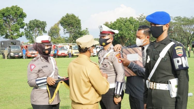 Wakil Bupati Simalungun menyempatkan tanda pita kepada perwakilan personil yang melaksanakan tugas pengamanan yakni Basat Lantas, Denpom 1/I Pematangsiantar, Dinas Perhubungan (Dishub) dan Satuan Polisi Pamong Praja (Satpol PP) sebagai pertanda dimulainya Ops Ketupat Toba 2021, di wilayah hukum Polres Simalungun.