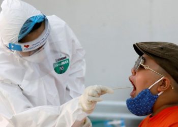 Petugas kesehatan di Vietnam sedang mengambil sampel dari salah satu warga untuk uji spesimen Covid-19. (Foto: Reuters)