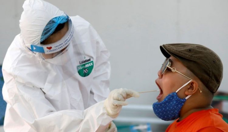 Petugas kesehatan di Vietnam sedang mengambil sampel dari salah satu warga untuk uji spesimen Covid-19. (Foto: Reuters)