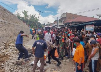 Anggota TNI - POLRI dibantu warga saat mengevakuasi korban.