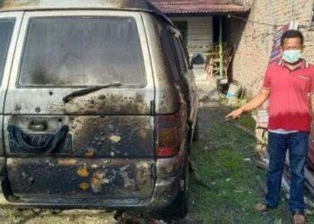 Wartawan televisi Pujianto memperlihatkan mobilnya yang dibakar oleh OTK. [Ist]