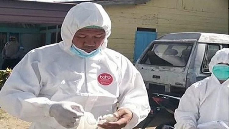 Kapolsek Dolok Sanggul Iptu Tukkar L Simamora mengenakan APD untuk memakamkan jenazah pasien Covid-19. (Foto: Ist)