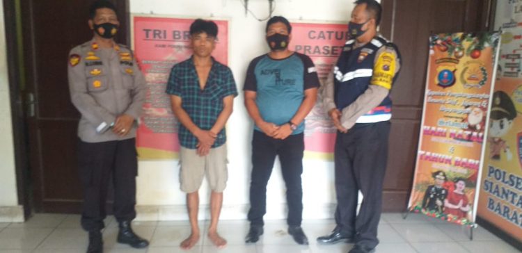 Pelaku penganiayaan (baju kotak - kotak) diapit petugas setelah diringkus dari Pasar Horas.