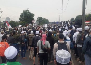 Massa pendukung Habib Rizieq Shihab bertahan di kawasan Flyover Pondok Kopi pada Kamis (24/6/2021). Akibatnya akses jalan dari dan menuju Bekasi macet. [Suara.com/Yaumal]