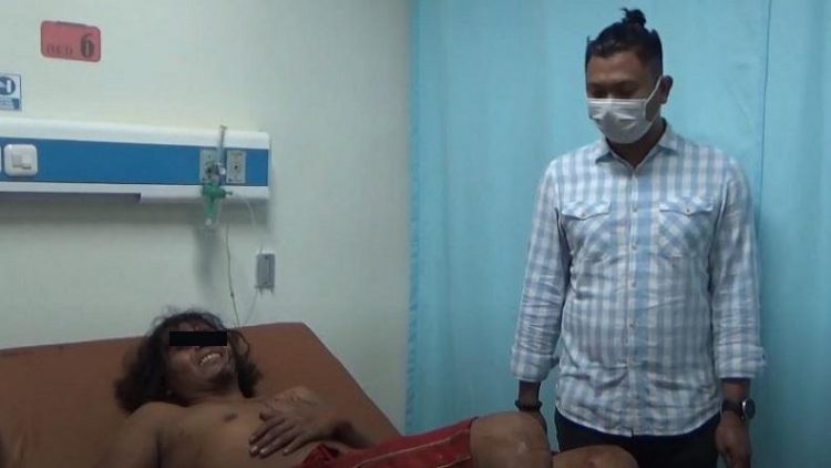 Suryanto alias Anto Dogol (35) pembunuh Ketua MUI Labura meringis kesakitan saat dibawa ke rumah sakit usai diberikan tindakan tegas terukur karena melawan. (Foto: iNews/Ikang Amanda)