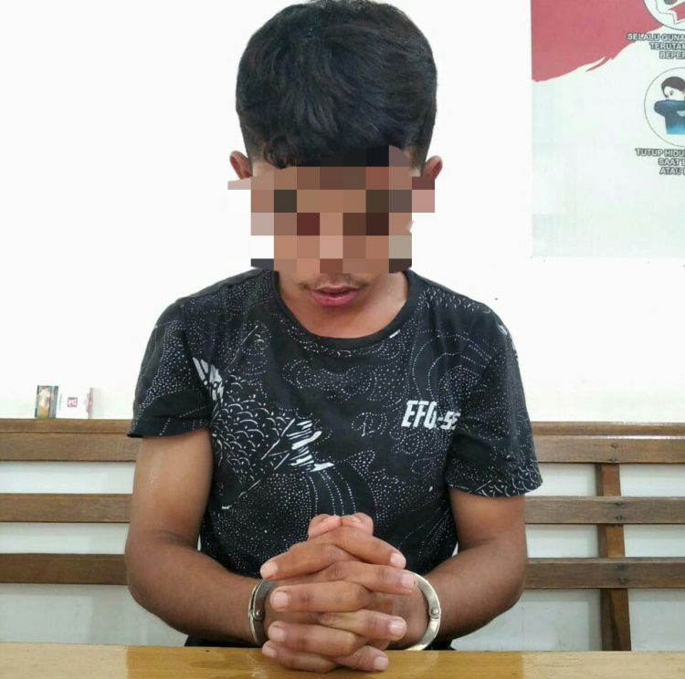 Foto pelaku cabul saat di kantor polisi dengan tangan diborgol.
