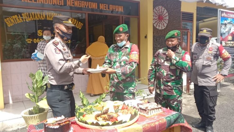 Danramil Model 08/STR, Kapten Arh P. Siagian, memberikan surprise dengan membawa kue tart dan nasi tumpeng, kemudian menyerahkannya kepada Kapolsek Bangun, AKP L.S Gultom SH.