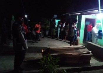 Petugas bersama warga saat mengevakuasi mayat korban.