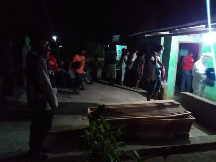 Petugas bersama warga saat mengevakuasi mayat korban.