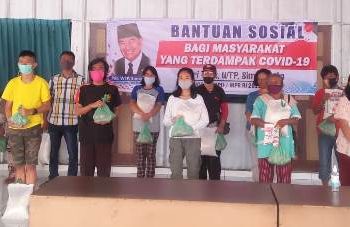 Warga penerima bantuan sembako saat foto bersama usai menerima bantuan dari Anggota DPD RI, Pdt Willem TP Simarmata.