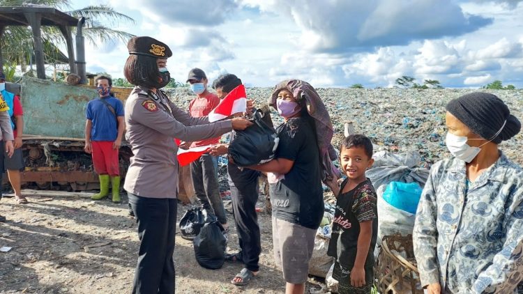 Salah seorang Polwan Polres Pematangsiantar saat menyerahkan paket sembako kepada pemulung di TPA Pematangsiantar.