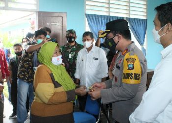 Kapolres Pematangsiantar, AKBP Boy Sutan Binanga Siregar, S.I.K, saat menyerahkan bantuan kepada salah seorang warga penerima.