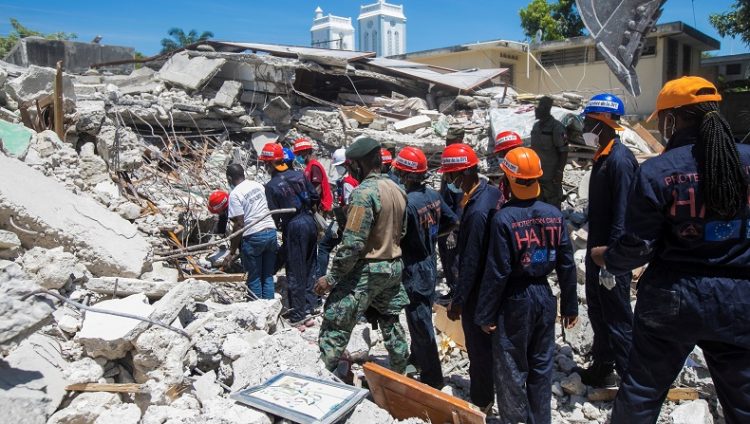 Anggota tim penyelamat dan perlindungan membersihkan puing-puing sebuah rumah setelah gempa di Les Cayes, Haiti, 15 Agustus 2021. (Foto: REUTERS)
