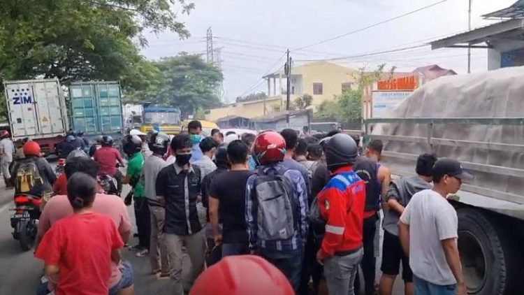 Warga berkerumun di lokasi kecelakaan mengerikan pengendara motor perempuan tewas terlindas truk kontainer di Belawan, Kota Medan. (foto: iNews/Yudha Bahar)