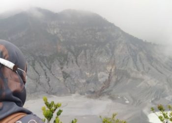Seorang wisatawan tengah menikmati pemandangan salah satu kawah di Gunung Tangkuban Parahu. [Suara.com/Ferrye Bangkit Rizki]