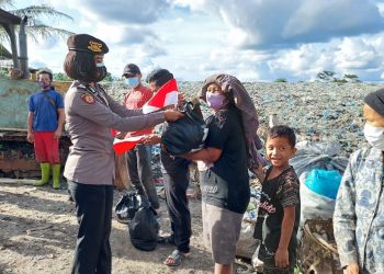 Salah seorang Polwan Polres Pematangsiantar saat menyerahkan paket sembako kepada pemulung di TPA Pematangsiantar.