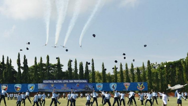 Lulusan Sekbang A-98 melempar topi ke udara saat tim aerobatik TNI AU melintas memeriahkan upacara wingday di Lapangan Jupiter Lanud Adisutjipto Yogyakarta, Rabu (4/8/2021). (Foto: Dok Pentak Lanud Adisuttjipto Yogyakarta)