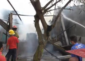 Sejumlah petugas pemadam kebakaran saat memadamkan api yang membakar dua unit rumah di Marindal, Deliserdang, Minggu petang (12/9/2021). Foto: iNewsTV/Ahmad Ridwan Nasution