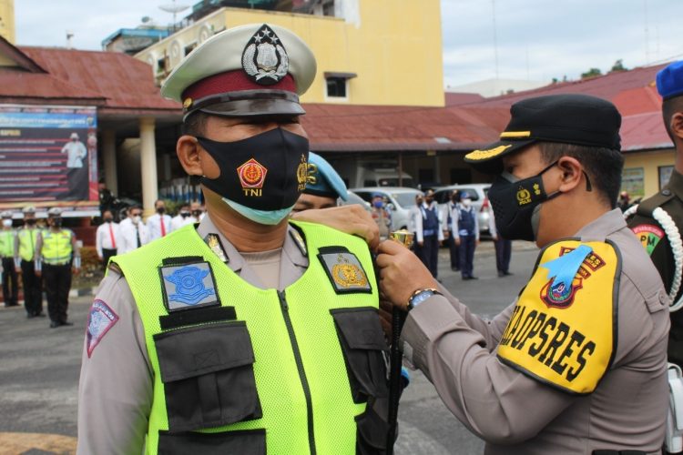 Kapolres Pematangsiantar, AKBP Boy Sutan Binaga Siregar S.I.K, menyematkan pita kepada salah seorang personel Sat Lantas Polres Pematangsiantar, tanda Operasi Patuh Toba 2021 resmi digelar.